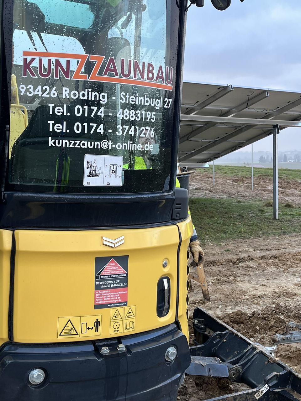 Minibagger von Kunz Zaunbau für Fundamente und Erdarbeiten vor einer PV-Anlage
